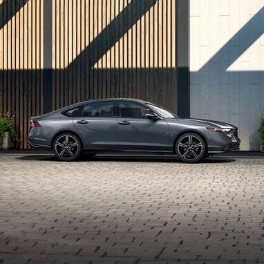 Profile view of 2026 Honda Accord parked against the rooftop structure of the parking garage.